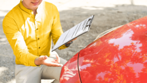 man checking scratch on car bumper
